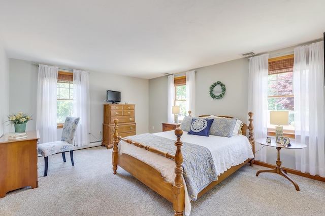 bedroom with light colored carpet and multiple windows