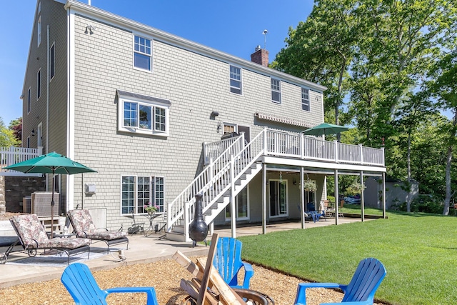 back of property featuring a patio, a wooden deck, and a yard