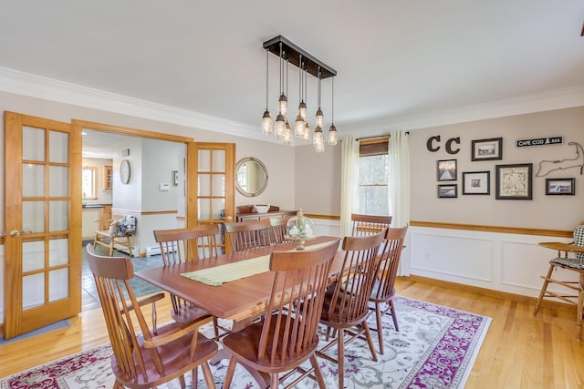 dining area featuring ornamental molding, a baseboard heating unit, and light hardwood / wood-style floors