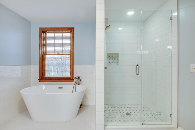 bathroom featuring separate shower and tub and tile walls