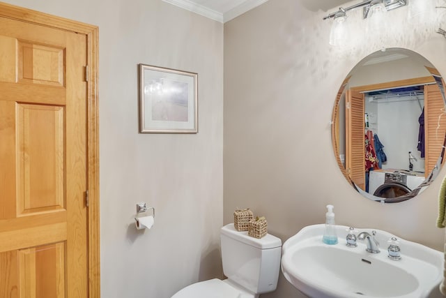 bathroom with washer / clothes dryer, ornamental molding, sink, and toilet