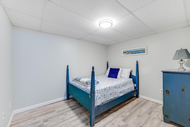 bedroom featuring hardwood / wood-style flooring and a paneled ceiling