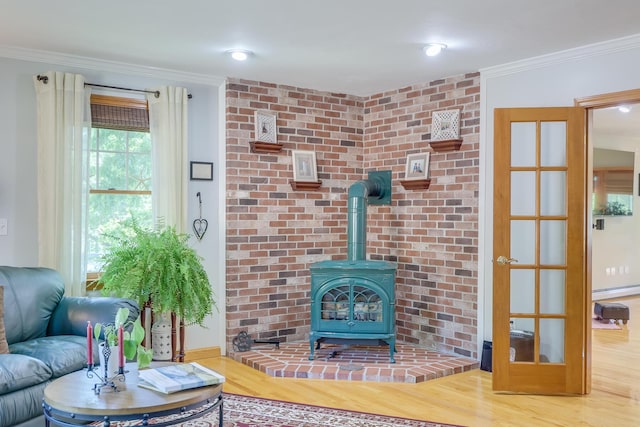 living room with wood-type flooring, ornamental molding, and a wood stove