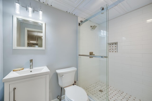 bathroom featuring vanity, toilet, and a shower with shower door