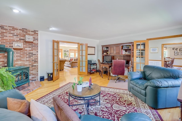 living room featuring ornamental molding, a wood stove, light hardwood / wood-style flooring, and french doors