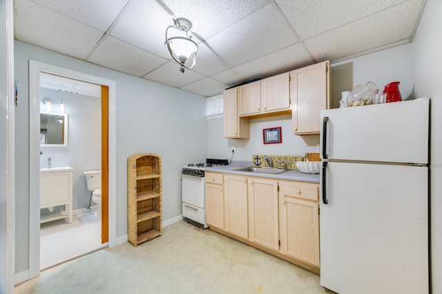 kitchen with white appliances, light brown cabinetry, a paneled ceiling, and sink