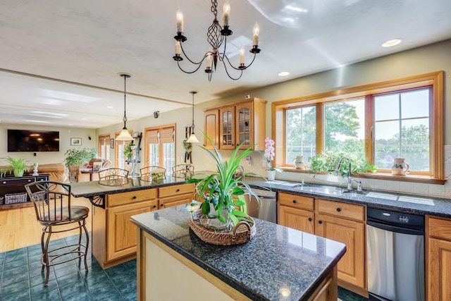 kitchen featuring a kitchen island, sink, dark stone countertops, and a kitchen breakfast bar