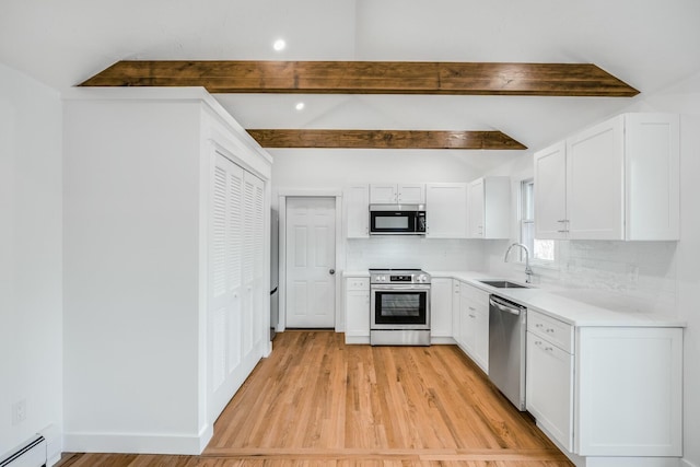 kitchen featuring a sink, a baseboard heating unit, backsplash, stainless steel appliances, and vaulted ceiling with beams