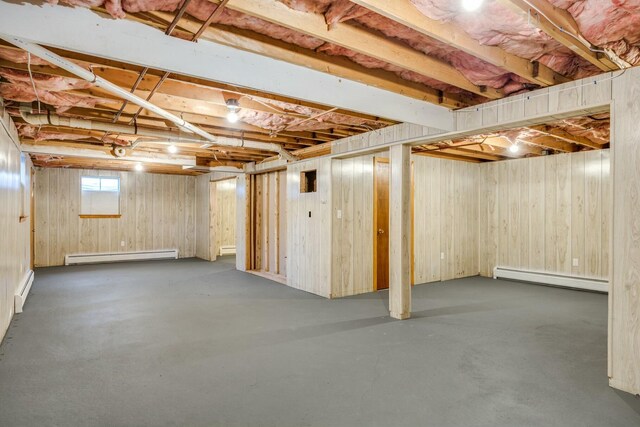 basement with baseboard heating and wood walls