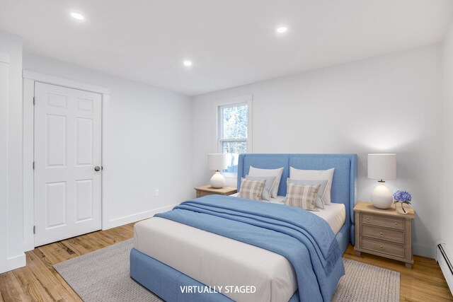 bedroom with recessed lighting, baseboards, baseboard heating, and light wood finished floors