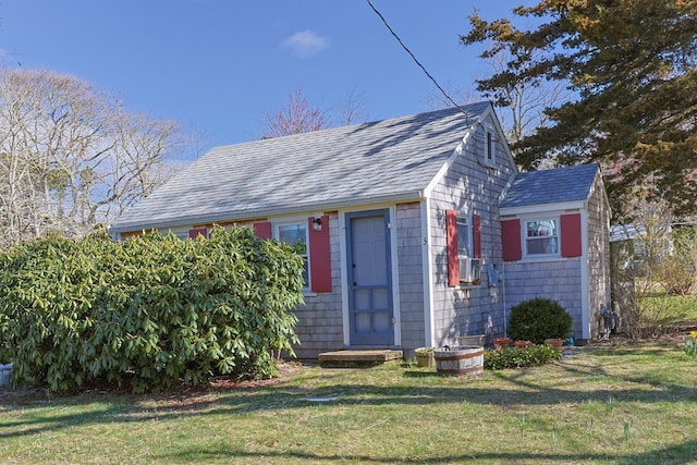 view of front of property featuring roof with shingles and a front yard
