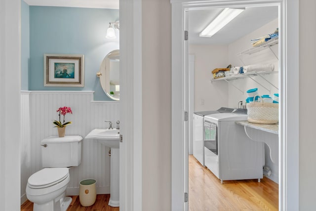 36 Pheasant Cove Cir, Yarmouth Port, MA 02675 - bathroom featuring a wainscoted wall, wood finished floors, toilet, and washing machine and dryer