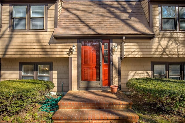 doorway to property with a shingled roof