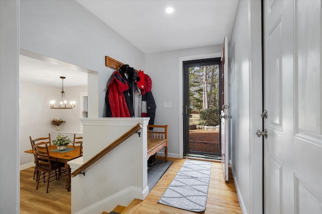 interior space featuring an inviting chandelier, light wood-style flooring, and baseboards