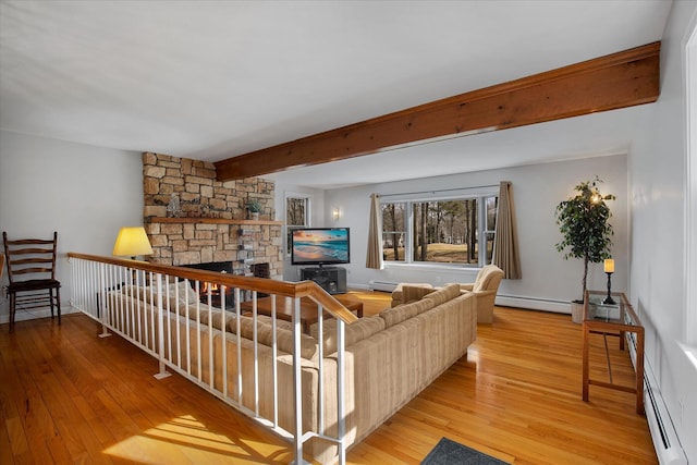 living room featuring a stone fireplace, beamed ceiling, a baseboard radiator, and wood finished floors