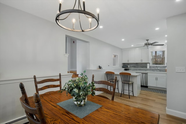 dining room with ceiling fan with notable chandelier, a baseboard radiator, light wood-style flooring, and recessed lighting