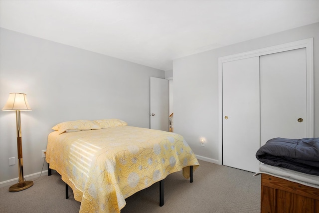 carpeted bedroom featuring a closet and baseboards