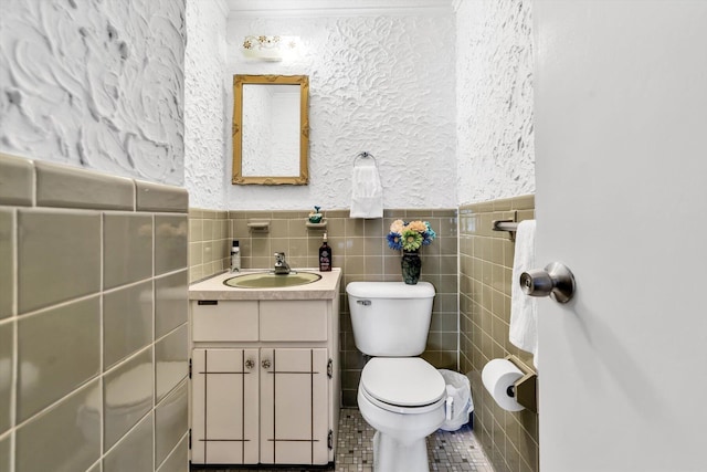 bathroom with vanity, toilet, tile patterned flooring, and tile walls