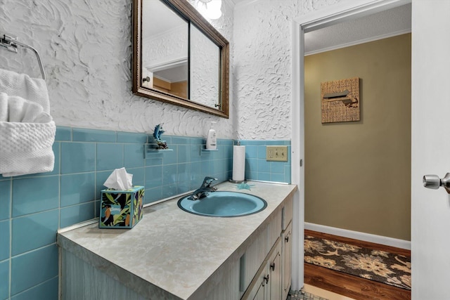 bathroom with ornamental molding, vanity, and hardwood / wood-style floors