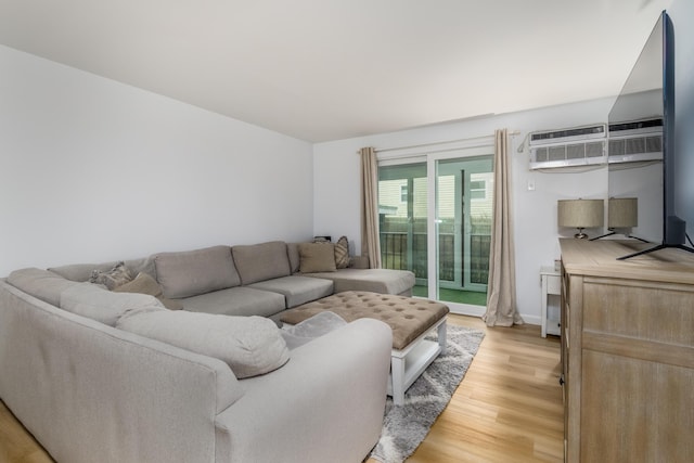 living room with light hardwood / wood-style flooring and a wall mounted air conditioner