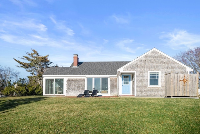 view of front of home with roof with shingles, a chimney, and a front lawn