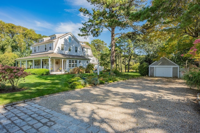 view of front of house with a porch, a garage, a front yard, and an outdoor structure