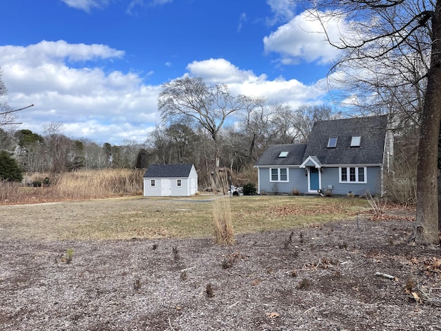16 Regency Dr, Sagamore, MA 02561 - view of front of property with an outdoor structure, roof with shingles, a shed, and a front yard