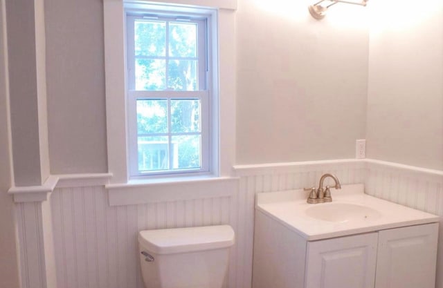 16 Regency Dr, Sagamore, MA 02561 - half bathroom featuring a wainscoted wall, toilet, and vanity