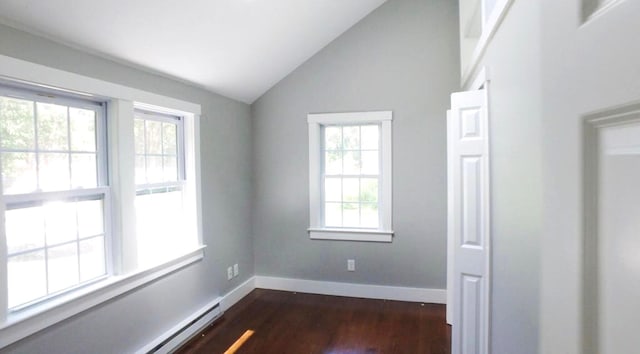 spare room featuring vaulted ceiling, dark wood-type flooring, a baseboard radiator, and baseboards