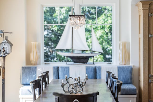 dining space featuring arched walkways, a wealth of natural light, and a chandelier