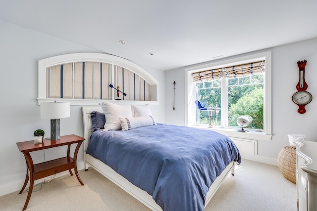 bedroom with light carpet and baseboards