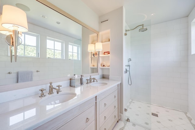 full bath featuring double vanity, a walk in shower, and a sink