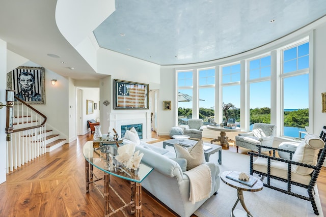 living room with a premium fireplace, stairway, baseboards, and light wood-style flooring