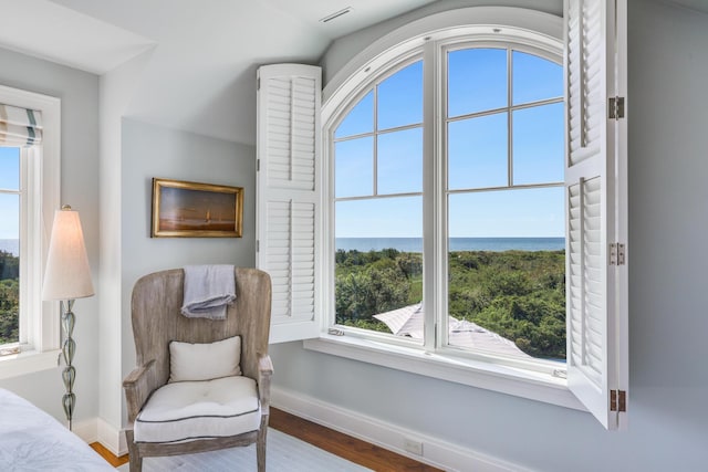 sitting room featuring wood finished floors, baseboards, and a water view