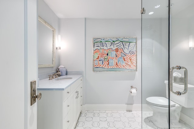 bathroom featuring vanity, toilet, and baseboards