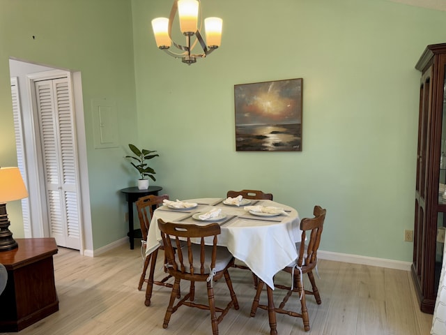 dining area featuring a chandelier, light wood-type flooring, and baseboards