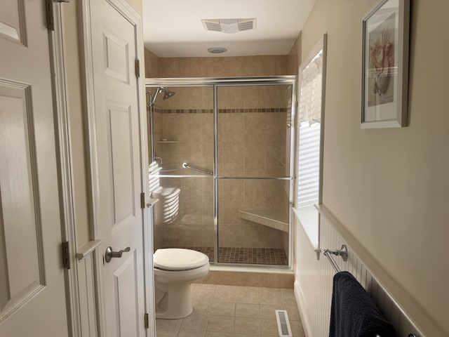 bathroom featuring toilet, a shower stall, visible vents, and tile patterned floors