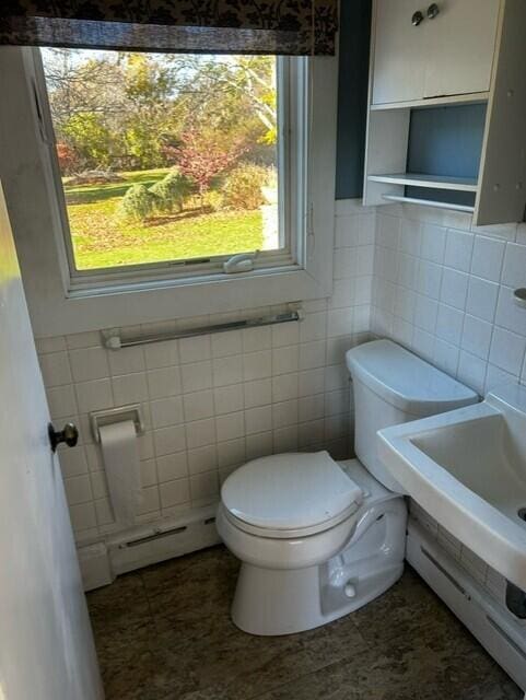 bathroom with a baseboard radiator, toilet, and tile patterned floors