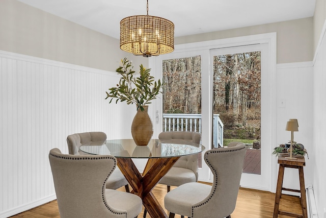 dining area with hardwood / wood-style floors and a notable chandelier