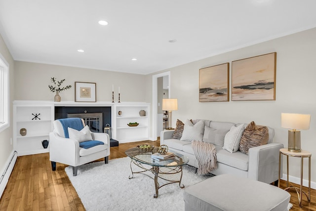 living room featuring a baseboard heating unit and wood-type flooring