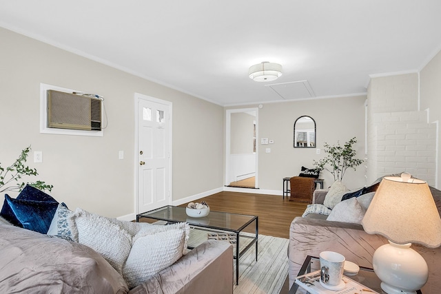 living room with hardwood / wood-style flooring, ornamental molding, and a wall unit AC