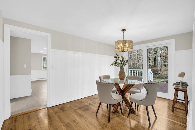 dining room with a notable chandelier, hardwood / wood-style floors, and baseboard heating