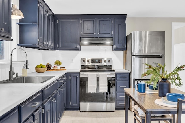 kitchen with sink, blue cabinetry, decorative backsplash, and stainless steel appliances