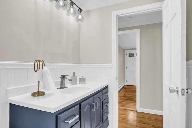 bathroom featuring vanity, a baseboard heating unit, and hardwood / wood-style floors