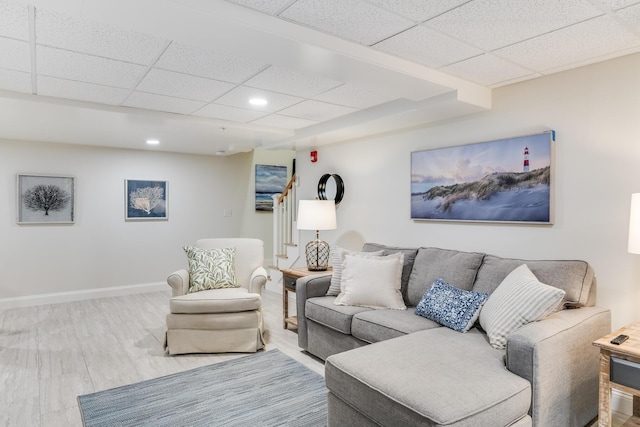 living room with recessed lighting, stairway, wood finished floors, a drop ceiling, and baseboards