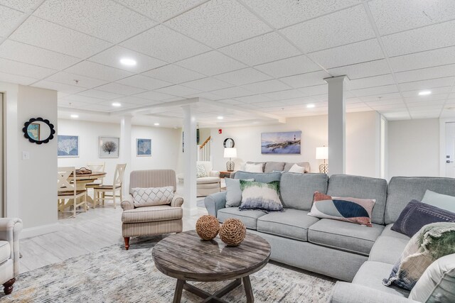 living area featuring baseboards, a drop ceiling, wood finished floors, and recessed lighting