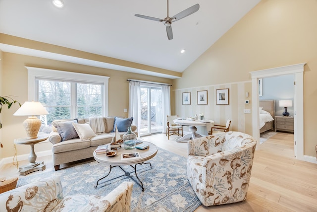 living area featuring baseboards, light wood-style flooring, ceiling fan, high vaulted ceiling, and recessed lighting