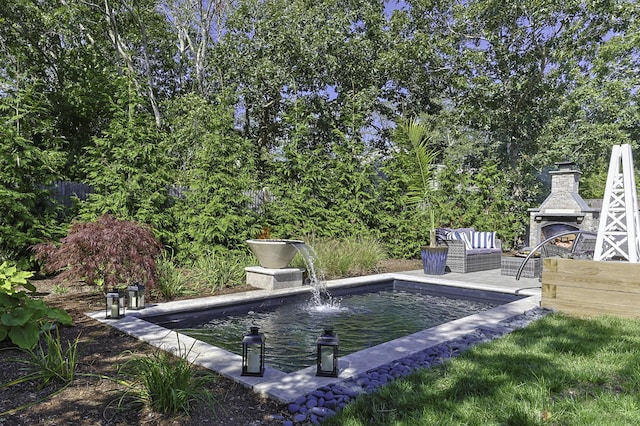 view of swimming pool featuring fence and an outdoor fireplace