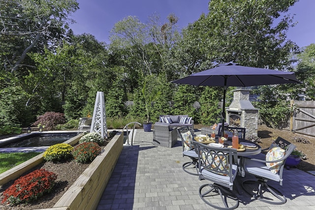 view of patio / terrace featuring fence and an outdoor living space with a fireplace