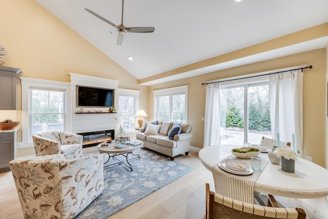 living area with ceiling fan, light wood-style floors, a fireplace, high vaulted ceiling, and recessed lighting